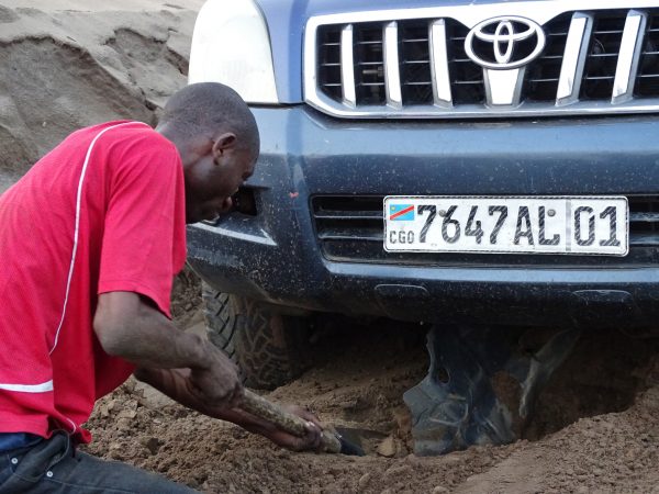 19 Our driver, Reagan Matu, digging the engine protection plate that is broken. This happen after having already broken two tires and the assisted direction of the steering wheel